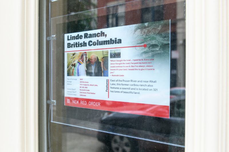 A printed informational sign about Linde Ranch, British Columbia, is taped to a glass door or window. The sign includes text, a photo, and a red "New Red Order" label at the bottom.