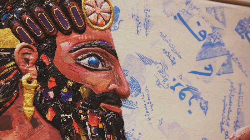 A detailed mosaic of a bearded figure's face on the left, with Arabic script and designs on the right side of the image.